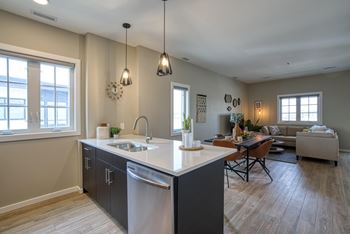 A kitchen with a dining table and chairs in the background.